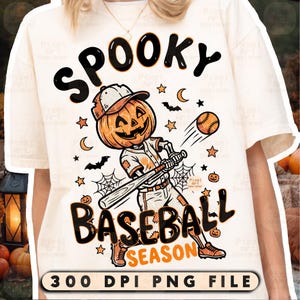 May include: A cream-colored t-shirt featuring a graphic of a skeleton with a pumpkin head playing baseball. The text reads SPOOKY BASEBALL SEASON and 300 DPI PNG FILE. The design includes bats, stars, spiderwebs, and small pumpkins in orange and black.