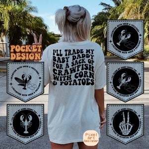 May include: A white t-shirt with a black graphic that says "I'll trade my baby daddy for a sack of crawfish with corn & potatoes". The graphic is in a retro font. There are four black and white patches with crawfish and corn designs on the shirt.