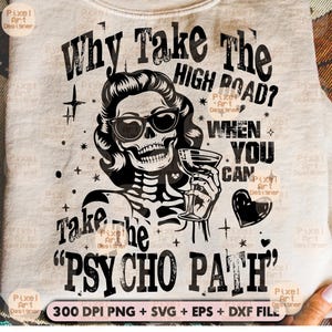 Puede incluir: Camiseta de color claro con una ilustración en blanco y negro de una mujer esqueleto con gafas de sol y un cóctel. El texto dice "Why Take The High Road? When You Can Take The 'Psycho Path'" con elementos de diseño.