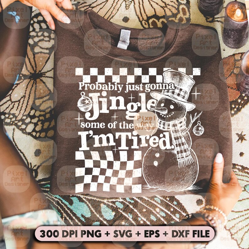 May include: A brown sweatshirt with the text "Probably just gonna Jingle some of the way I'm Tired" and a graphic of a snowman wearing a hat and scarf. The design includes a checkered pattern.