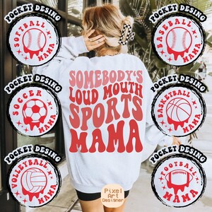 May include: White sweatshirt with the text "Somebody's Loud Mouth Sports Mama" in red and pink. The sweatshirt has six different sports-themed pocket designs with the text "Pocket Desing" and "Mama" in black.