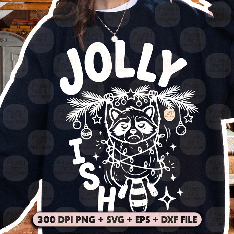May include: A black sweatshirt featuring a white graphic of a raccoon hanging from a pine branch wrapped in string lights. The text JOLLY ISH is printed in large white letters. Below the graphic, the text 300 DPI PNG + SVG + EPS + DXF FILE appears.