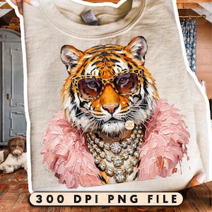Könnte beinhalten: Ein beiges Sweatshirt mit einer Grafik eines Tigers, der eine Sonnenbrille mit Leopardenmuster, eine mehrlagige Kristallkette und einen strukturierten rosa Kunstfellkragen trägt. Das Motiv zeigt einen dicken Farbauftrag.