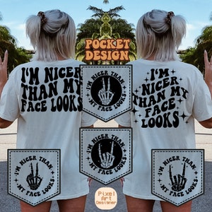 May include: A white t-shirt with a black pocket design. The pocket design features a skeleton hand making a peace sign inside a circle with the text "I'm nicer than my face looks".