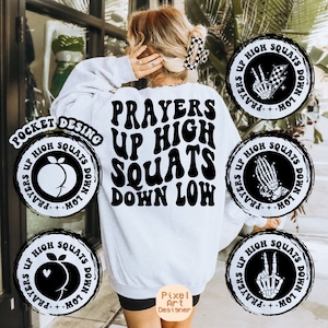 May include: White sweatshirt with the text "Prayers Up High Squats Down Low" in black, retro-style font. The sweatshirt has a pocket on the left side with a smaller version of the text and a peach graphic.