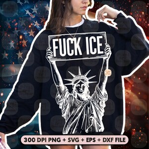 Puede incluir: Sudadera negra con un gr&aacute;fico blanco de la Estatua de la Libertad sosteniendo un letrero que dice "FUCK ICE". El fondo presenta un dise&ntilde;o de bandera estadounidense. La sudadera tiene un cuello blanco.