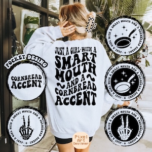 Puede incluir: Sudadera blanca con texto negro que dice "Just a girl with a smart mouth and a cornbread accent". El texto está en una fuente retro. Hay cuatro diseños circulares en blanco y negro alrededor del texto. Un diseño presenta una sartén, otro presenta un signo de paz y dos diseños presentan el texto "Cornbread Accent".