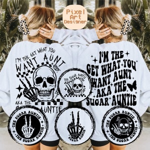May include: White sweatshirt with black text and graphic designs. The text reads "I'm the get what you want aunt aka the sugar auntie". The graphic designs are skulls and hands with peace signs.