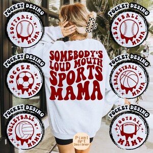 May include: White sweatshirt with red text that says "Somebody's Loud Mouth Sports Mama".  The sweatshirt has seven different sports-themed patches on the sleeves and bottom hem. The patches are black and white with red sports balls and the words "Pocket Desing" and "Mama".