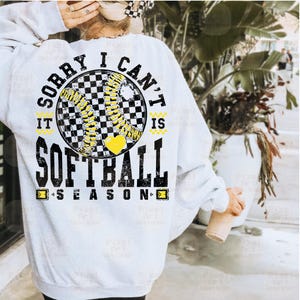 May include: White sweatshirt with a black and yellow softball graphic and the text "Sorry I can't it is softball season".