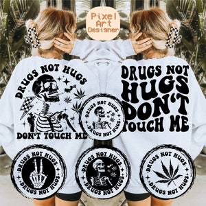 May include: White sweatshirt featuring the slogan "DRUGS NOT HUGS" and a skeleton illustration smoking. The design includes cannabis leaves, a lightning bolt, and the words "DON'T TOUCH ME". Several circular designs with related graphics are also shown.