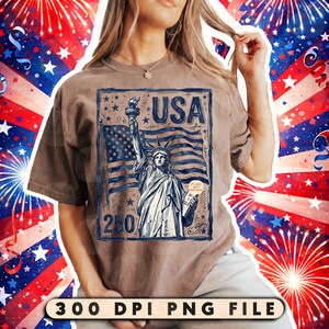 Może przedstawiać: Brązowa koszulka z niebiesko-białą grafiką przedstawiającą Statuę Wolności, amerykańską flagę i napis "USA". Grafika zawiera r&oacute;wnież tekst "250". Na dole obrazu widnieje napis "300 DPI PNG FILE".