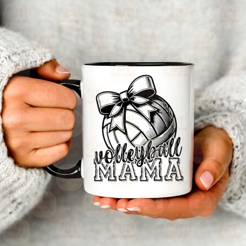 Może przedstawiać: Biały ceramiczny kubek do kawy z czarnym uchwytem. Kubek ma czarno-białą ilustrację piłki siatkowej z kokardką na g&oacute;rze. Tekst "volleyball mama" jest nadrukowany czarnym kolorem pod piłką siatkową.