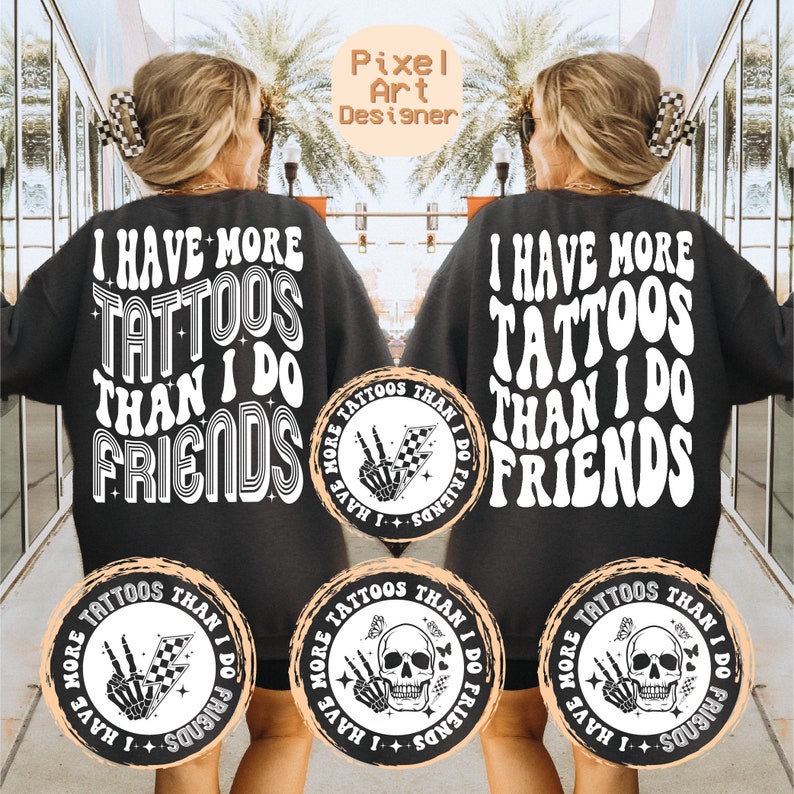 May include: Two black sweatshirts with white text that reads "I have more tattoos than I do friends".  Each sweatshirt has a circular design on the front with a skull and crossbones and the text "I have more tattoos than I do friends".