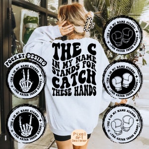 May include: A white sweatshirt with a black graphic design that says "The C in my name stands for catch these hands". The graphic is in a retro font style. There are four smaller black and white circular designs with different graphics on them.