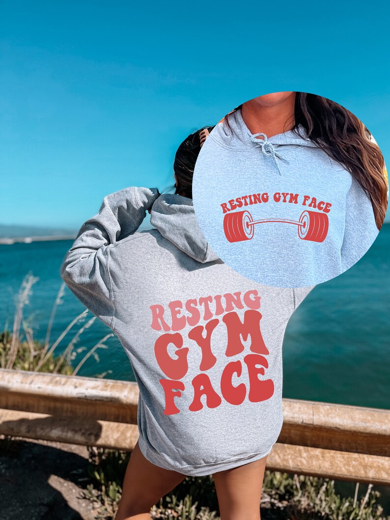 May include: A gray hoodie with the text "Resting Gym Face" in red letters on the back. The front of the hoodie has a smaller version of the text with a red barbell graphic.