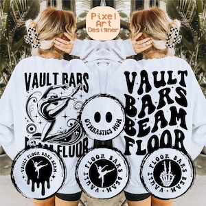 Puede incluir: Sudadera blanca con texto negro que dice "Vault Bars Beam Floor" y una cara sonriente con las palabras "Gymnastics Mom". Hay cuatro círculos más pequeños con el texto "Vault Floor Bars Beam" repetido en cada círculo.