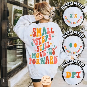 May include: White sweatshirt with a colorful retro design that says "Small Steps Still Move Us Forward". The design includes footprints and stars. The sweatshirt has a pocket with a design that says "Physical Therapist" and "DPT".