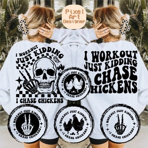 May include: A white sweatshirt with black text that reads "I workout just kidding I chase chickens". The text is in a retro font style. There are three smaller circles with the same text and a skull, chicken, and peace sign graphic.