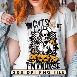 May include: White t-shirt with a Halloween-themed graphic. The design features a skeleton in a nurse's uniform holding a cup, surrounded by pumpkins. Text reads "You Can't Scare Me, I'm a Nurse."