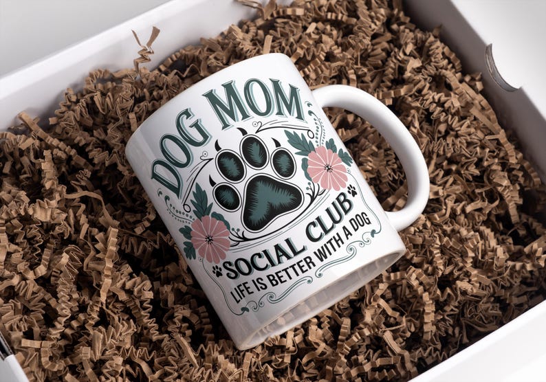 May include: White ceramic mug with a floral design and the text "Dog Mom Social Club Life is Better with a Dog".