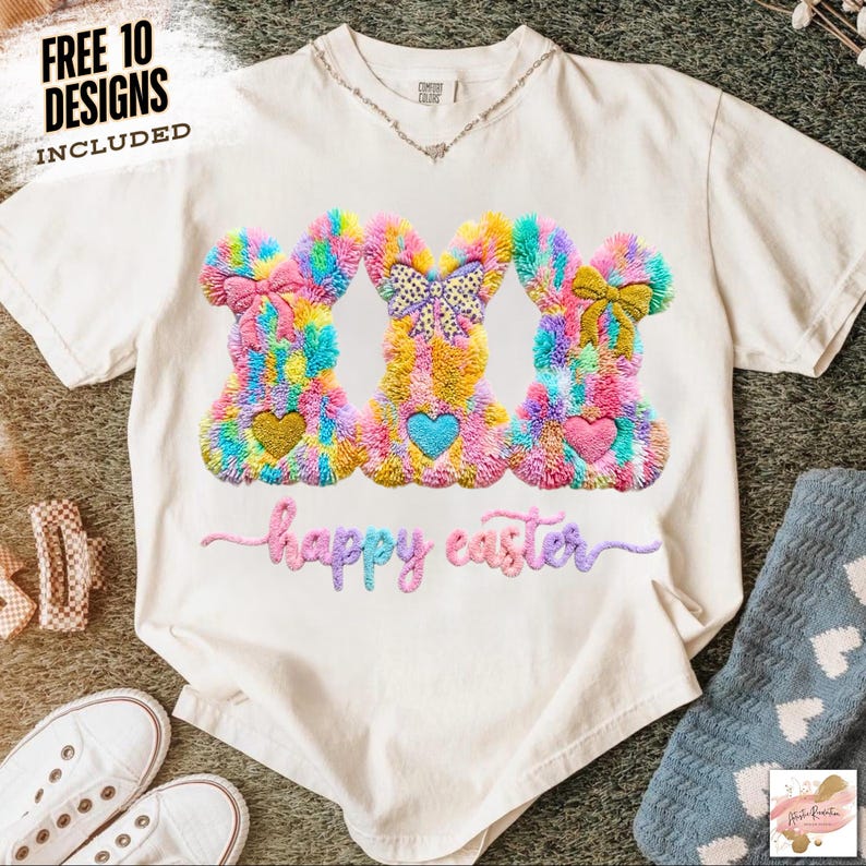 May include: White t-shirt featuring three colorful bunny designs with bows and heart accents. The phrase "happy easter" is embroidered below the bunnies. The text "FREE 10 DESIGNS INCLUDED" is in the upper left corner.
