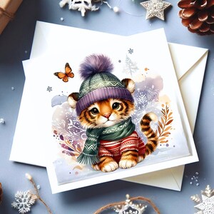 May include: A cute cartoon tiger cub wearing a purple and green knitted hat and scarf. The tiger is sitting on a snowy background with snowflakes and a butterfly.
