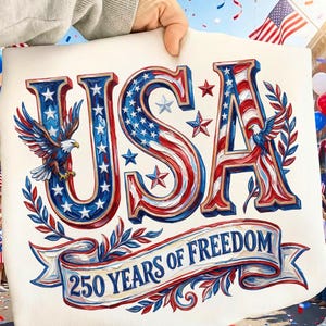 以下が含まれることがあります： 赤、白、青の星条旗柄で「USA」の文字が描かれた愛国的なデザイン。鷲と「250 Years of Freedom」の文字がバナーに描かれています。デザインは人が持っています。