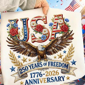 以下が含まれることがあります： 赤、白、青で「USA」の文字が描かれた愛国的なデザイン。花と翼を広げたワシが飾られています。「250年の自由」を1776年から2026年まで祝い、星とバナーが描かれています。