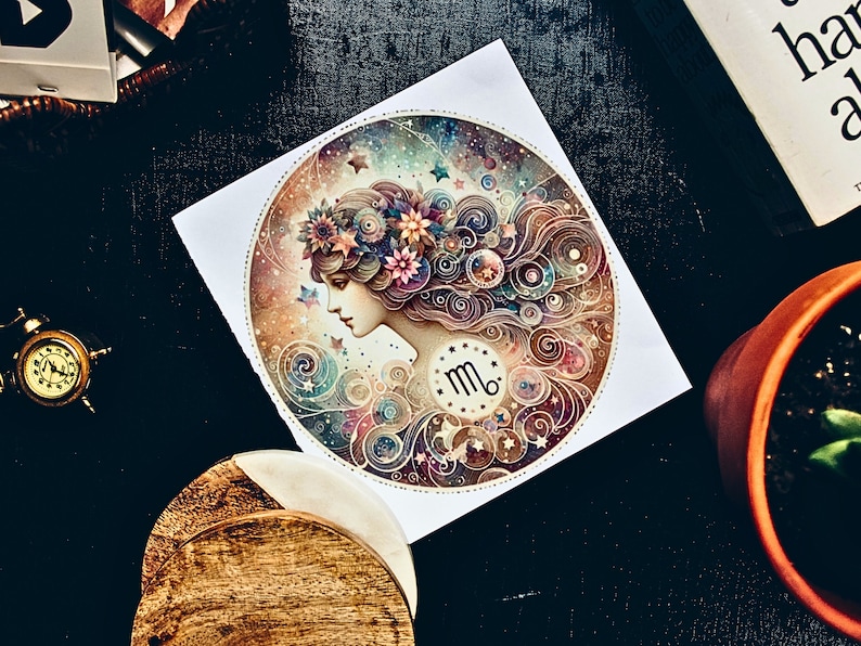 May include: A round, white paper print featuring a detailed illustration of a woman's profile with floral accents and a Virgo zodiac symbol. The artwork is surrounded by swirling patterns and stars, with a color palette of blues, pinks, and golds.