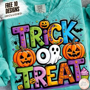 May include: A teal sweatshirt featuring a colorful graphic with the text TRICK OR TREAT. The design includes orange jack-o'-lanterns, a white ghost, a purple cupcake, spider webs, and small spiders. A tag at the neck reads COMFORT COLORS.