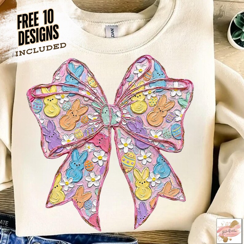 May include: Cream-colored sweatshirt featuring a large, colorful bow design. The bow is decorated with Easter-themed elements, including bunnies, eggs, and flowers in pastel colors. The text "FREE 10 DESIGNS INCLUDED" is printed at the top.
