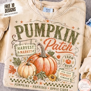 May include: A beige crewneck sweatshirt featuring a graphic print with the text PUMPKIN PATCH, HARVEST MARKET, FARM FRESH, and PICK YOUR PERFECT PUMPKIN. The design includes two orange pumpkins, autumn leaves, stars, and a checkered border.