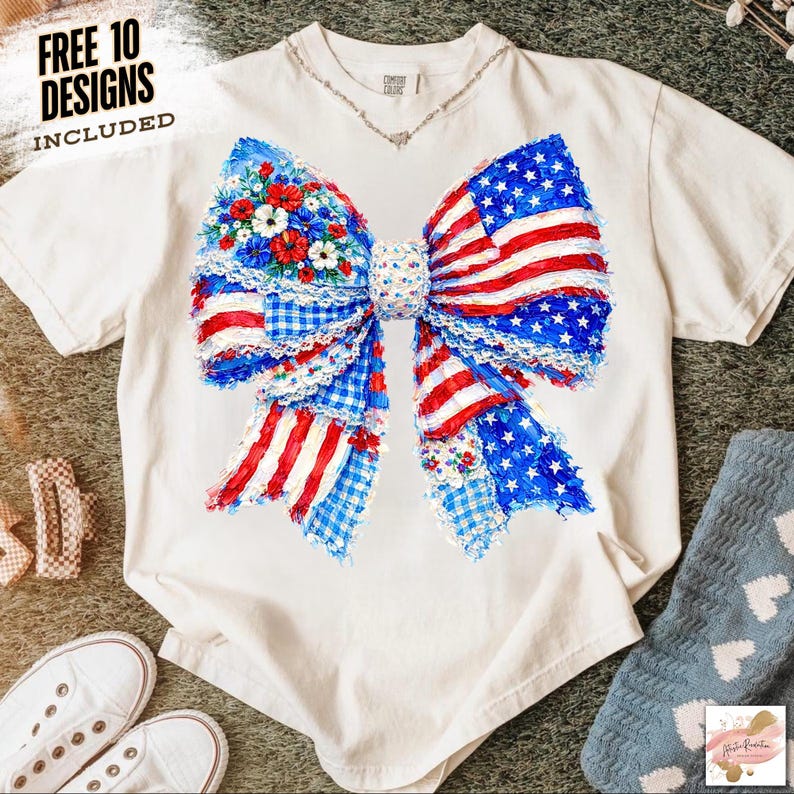 May include: White t-shirt featuring a large bow design with a patriotic theme. The bow incorporates elements of the American flag, with red and white stripes, blue stars, and floral accents. The text "FREE 10 DESIGNS INCLUDED" is visible.