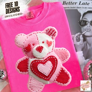 May include: Vibrant pink t-shirt featuring a stitched teddy bear design. The bear is in shades of pink, white, and red, with heart details. Text at the top left reads "FREE 10 DESIGNS INCLUDED".