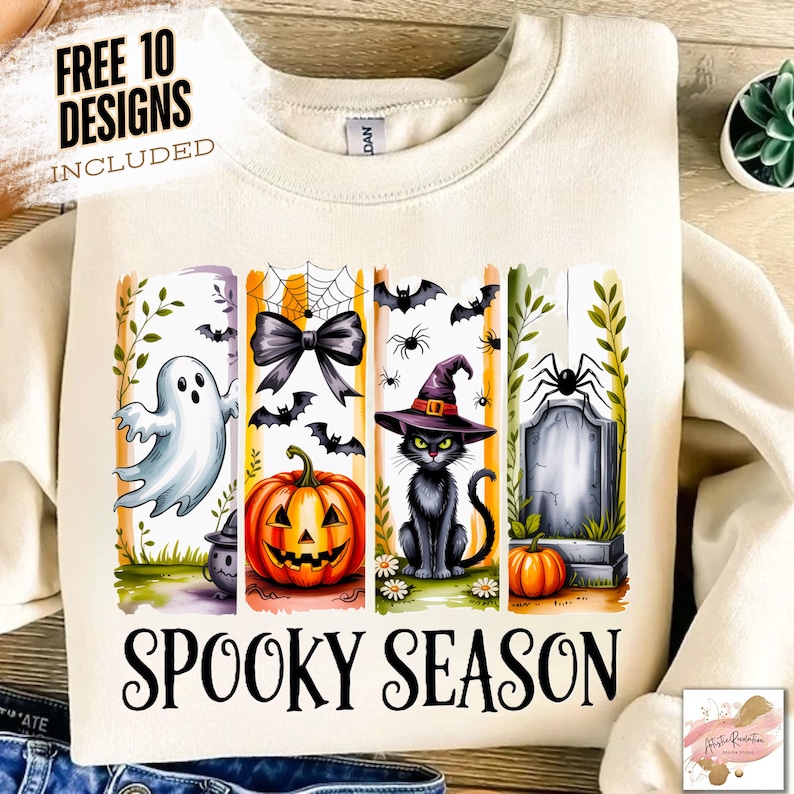 May include: Cream-colored sweatshirt with a Halloween-themed graphic. The design includes a ghost, jack-o'-lantern, black cat, spider, tombstone, and the words "Spooky Season". The text "Free 10 Designs Included" is also visible.