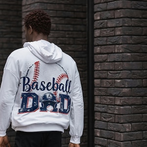 May include: White hooded sweatshirt with a baseball graphic and the text "Baseball Dad" printed on the back.