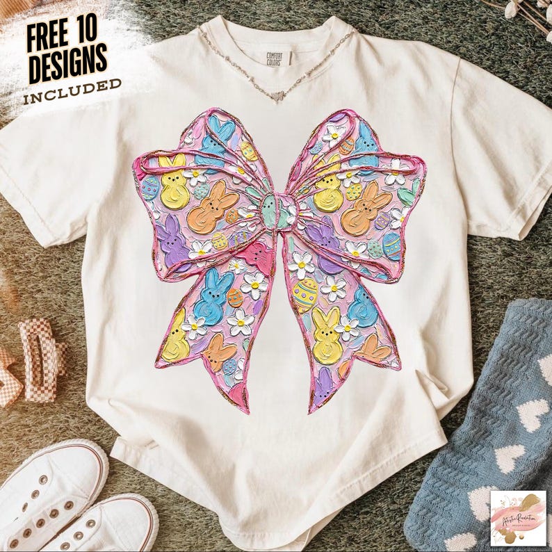 May include: Cream-colored t-shirt featuring a large, colorful bow design with Easter-themed elements. The bow is filled with bunnies, chicks, and Easter eggs in pastel colors. The text "FREE 10 DESIGNS INCLUDED" is in the upper left corner.