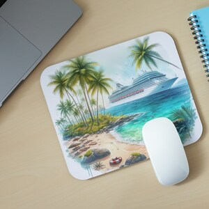 May include: A rectangular mousepad featuring a tropical beach scene with palm trees, a cruise ship, and a sandy shore. A white computer mouse is positioned on the mousepad. A laptop and a blue notebook are also visible.
