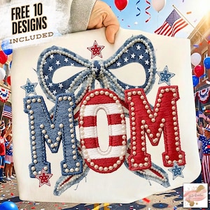 Pode incluir: Design bordado com a palavra "MOM" em vermelho, branco e azul, com um laço e estrelas. O design é adornado com contas peroladas e é segurado por uma mão. O fundo inclui uma bandeira americana e decorações festivas.