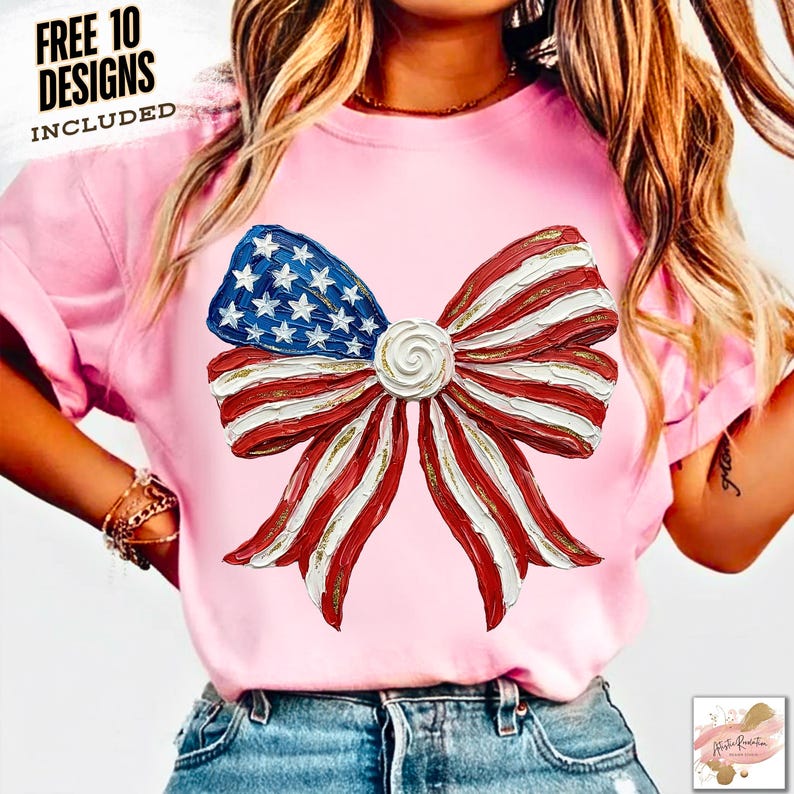 K&ouml;nnte beinhalten: Hellrosa T-Shirt mit einem patriotischen Schleifendesign. Die Schleife ist eine detaillierte Darstellung der amerikanischen Flagge, mit roten und wei&szlig;en Streifen, blauen Sternen und goldenen Akzenten. Der Text "FREE 10 DESIGNS INCLUDED" ist oben.