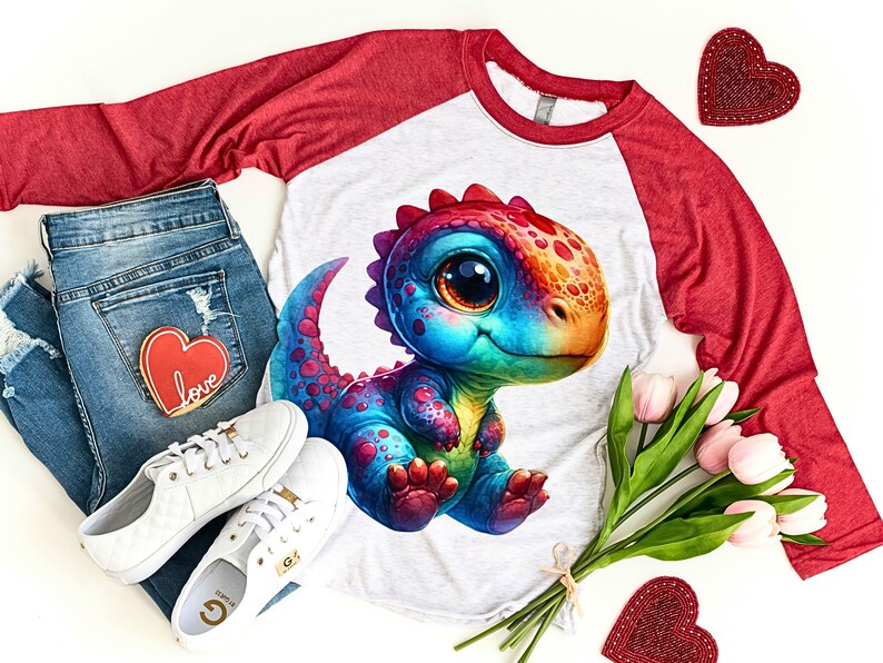 Puede incluir: Una camiseta de manga larga roja y gris con un gr&aacute;fico de dinosaurio arco&iacute;ris. El dinosaurio tiene ojos grandes y una expresi&oacute;n amigable. La camiseta es de estilo b&eacute;isbol con mangas rojas y cuerpo gris.