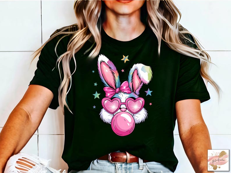 May include: A black t-shirt with a colorful cartoon bunny wearing pink heart-shaped sunglasses and blowing a pink bubble. The bunny has a pink bow on its head and is surrounded by stars.
