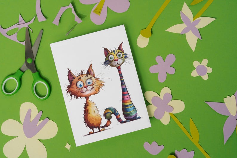 Puede incluir: Ilustraci&oacute;n caprichosa de dos gatos de dibujos animados con ojos grandes y rasgos expresivos. Un gato es naranja, el otro tiene un cuello a rayas arco&iacute;ris. La imagen est&aacute; sobre una tarjeta blanca, rodeada de flores de papel recortadas y tijeras sobre un fondo verde.