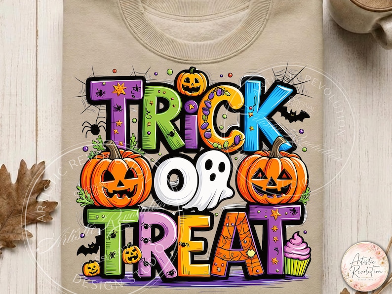 May include: A beige sweatshirt featuring a colorful graphic with the text TRICK OR TREAT. The design includes orange jack-o'-lanterns, a white ghost, a pink cupcake, spiders, spiderwebs, and bats, with each letter in a different bright color.