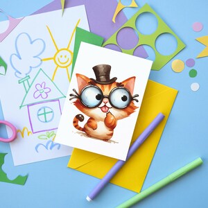 Pode incluir: Um cart&atilde;o branco com uma ilustra&ccedil;&atilde;o de desenho animado de um gato usando um chap&eacute;u-coco e &oacute;culos. O gato &eacute; laranja e branco com uma cauda preta. O cart&atilde;o est&aacute; rodeado por recortes de papel coloridos, tesoura e marcadores em um fundo azul claro.