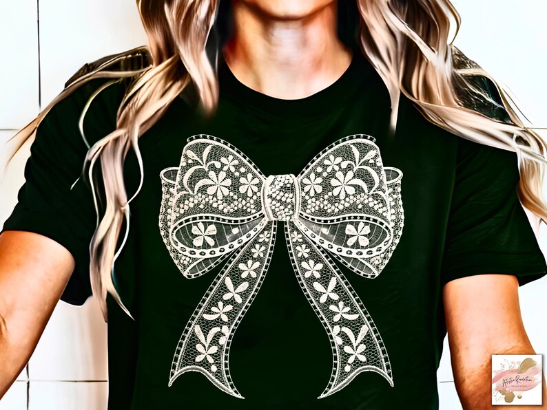 Puede incluir: Una camiseta negra con un dise&ntilde;o de lazo de encaje blanco. El lazo es intrincado y detallado, con un delicado patr&oacute;n floral.