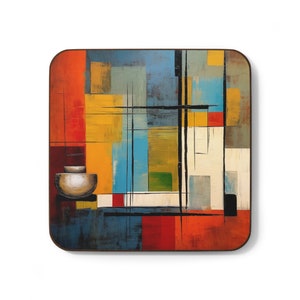 May include: Abstract art coaster with a geometric design in shades of yellow, red, blue, green, and white. The coaster features a black grid pattern and a small, white bowl.