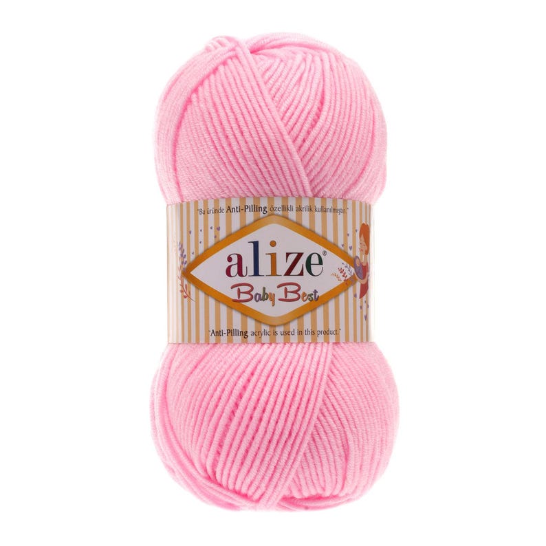 Puede incluir: Ovillo de lana rosa claro Alize Baby Best. La lana est&aacute; envuelta con una etiqueta que dice "alize Baby Best" en una fuente decorativa. La etiqueta tambi&eacute;n incluye texto en un idioma extranjero e indica que se utiliza acr&iacute;lico antipilling.