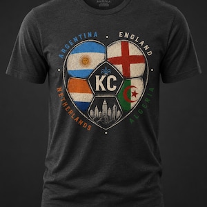 Puede incluir: Una camiseta de manga corta en gris jaspeado oscuro con un gr&aacute;fico de un bal&oacute;n de f&uacute;tbol en forma de coraz&oacute;n. Los paneles del bal&oacute;n muestran las banderas de Argentina, Inglaterra, Pa&iacute;ses Bajos y Argelia, con las letras KC y una ciudad.